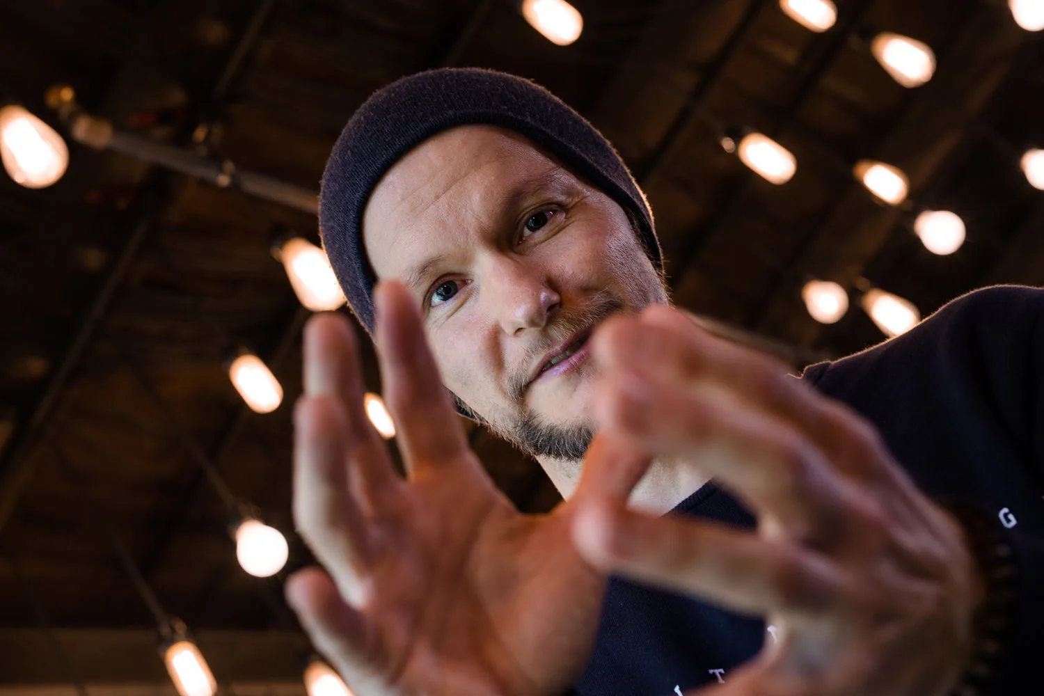 Kyrre Texnæs with his hand towards the camera, lights behind